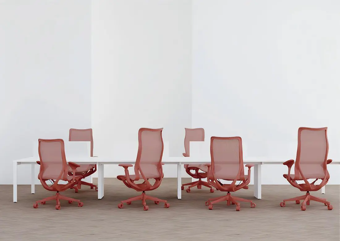 Canyon Red ergonomic mesh chairs arranged around white office workstations